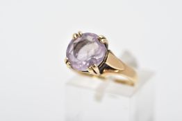 A 9CT GOLD AMETHYST RING, designed with a double four claw set circular cut amethyst, textured