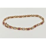 A 9CT GOLD RUBY AND DIAMOND LINE BRACELET, set with circular cut rubies, interspaced with illusion