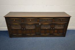 AN EARLY 20TH CENTURY OAK SIDEBOARD, four drawers above four cupboard drawers enclosing fixed