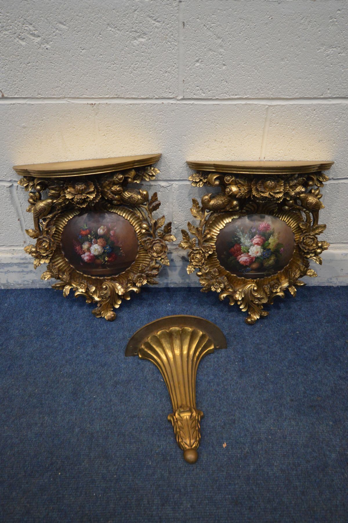A PAIR OF LATE 20TH CENTURY GILTWOOD WALL SHELVES, florally carved surrounding a convex painting