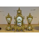 A 20TH CENTURY BRASS AND PORCELAIN CLOCK GARNITURE, the porcelain panels transfer printed with