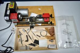 A MOUNTED 'EMCO UNIMAT 4' LATHE, mounted on a single wooden drawer, together with instruction manual