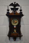 AN WALNUT VIENNA WALL CLOCK, with central eagle finial, enclosing a 5ins dial, height 80cm (