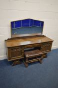 AN OAK GOTHIC DRESSING TABLE with a shaped mirror, two cupboard doors flanking a single drawer,