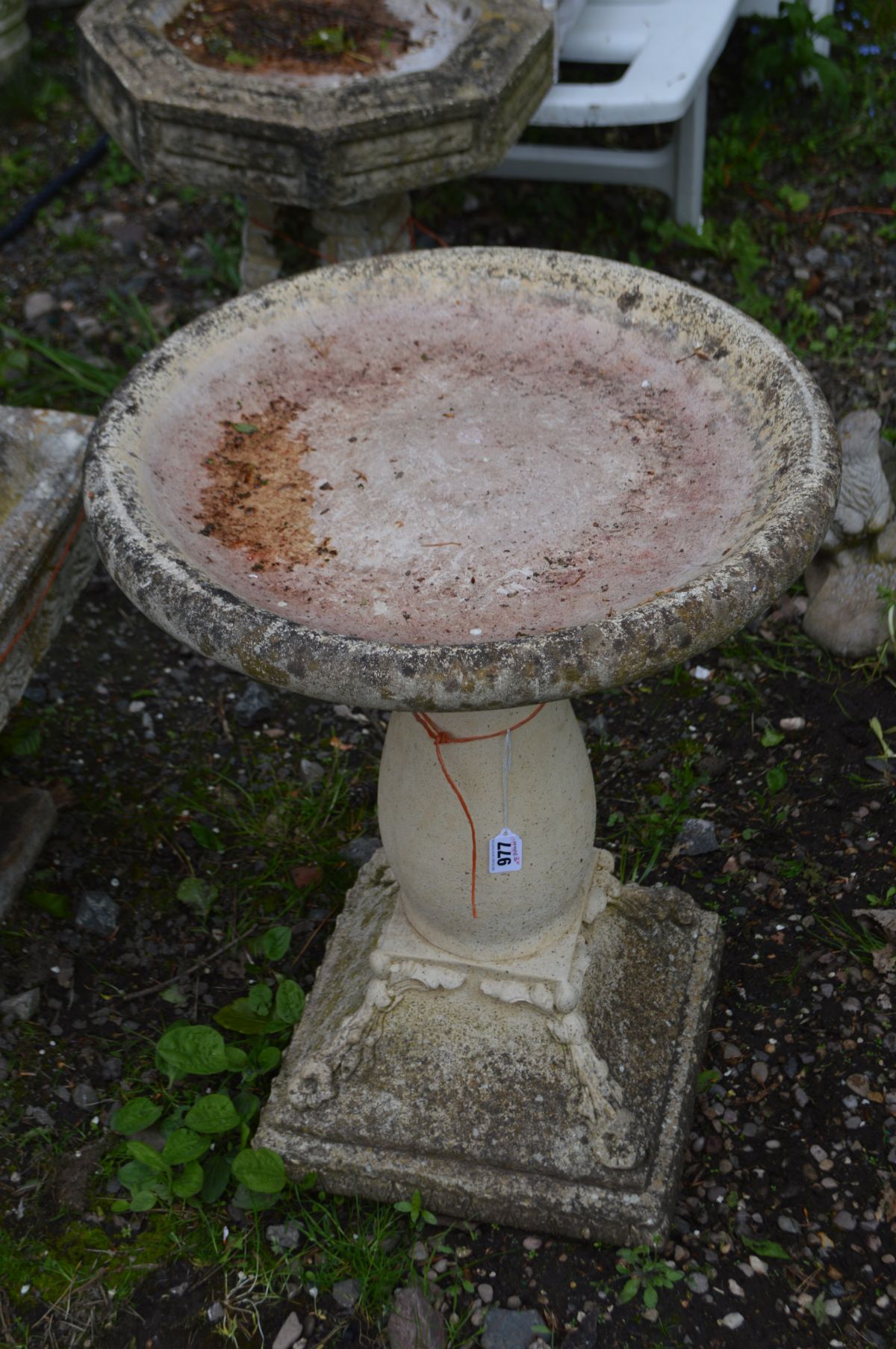 A COMPOSITE CIRCULAR BIRD BATH on a separate pillar base with foliate decoration, diameter 50cm x