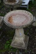 A COMPOSITE CIRCULAR BIRD BATH on a separate pillar base with foliate decoration, diameter 50cm x