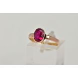A VICTORIAN YELLOW METAL RING, collet mounted oval cut synthetic ruby, plain polished band, rubbed
