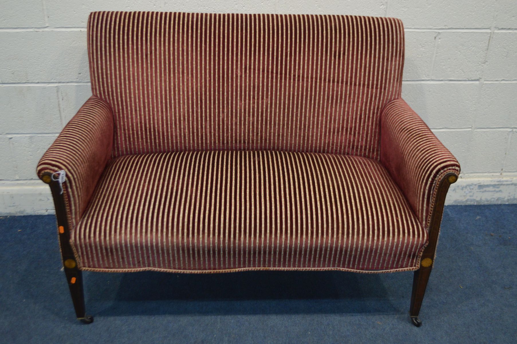 AN EDWARDIAN SOFA, on mahogany and inlaid square tapering legs, shaped back legs, reupholstered in