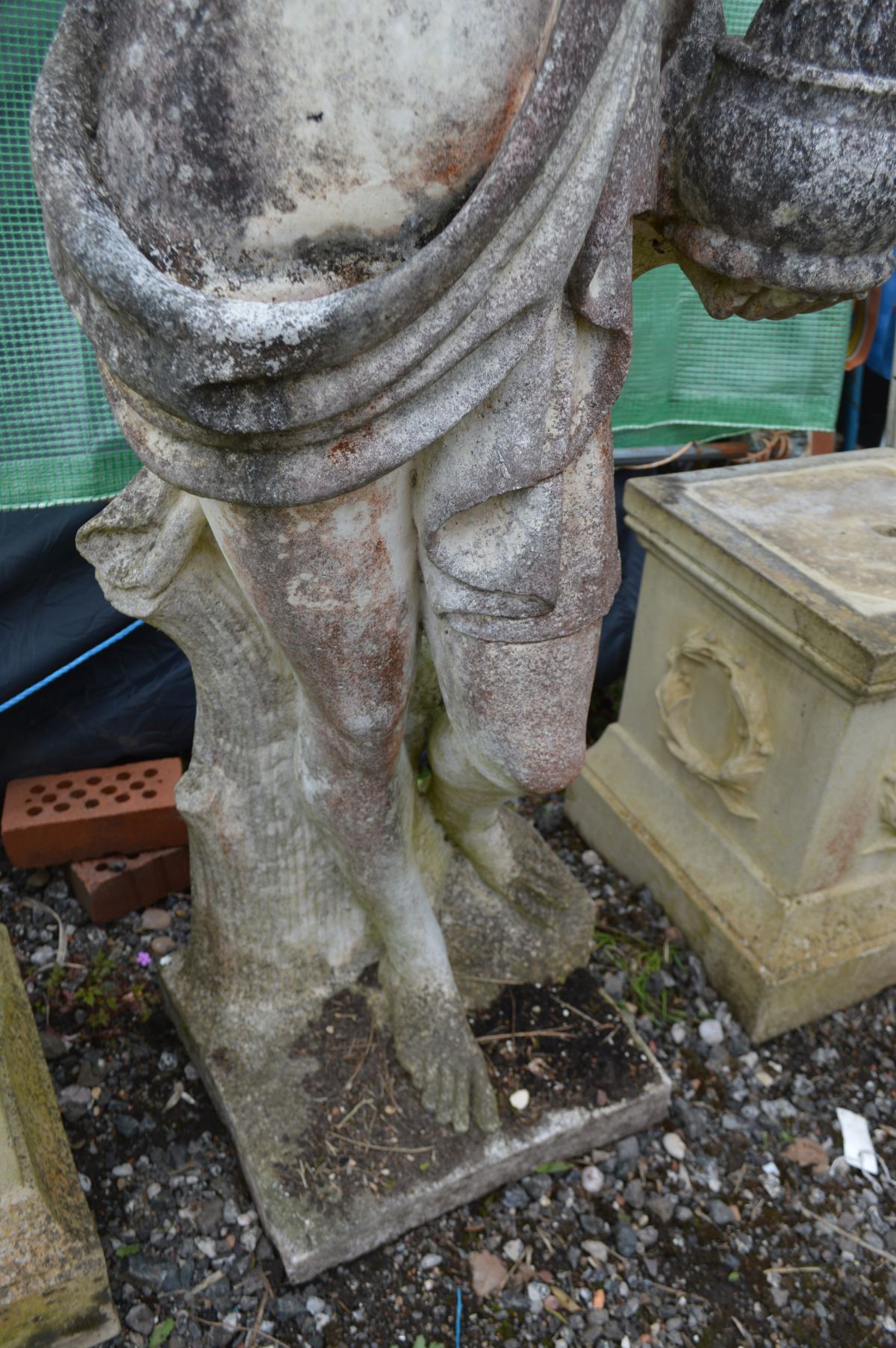A LARGE WEATHERED COMPOSITE GARDEN STATUE of a semi clad lady in flowing robes, holding a bowl, on a - Image 3 of 4