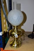 A BRASS BASED TABLE LAMP OF OIL LAMP FORM, with glass chimney and opaque glass shade, lack plug so