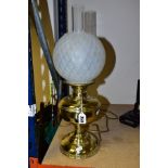 A BRASS BASED TABLE LAMP OF OIL LAMP FORM, with glass chimney and opaque glass shade, lack plug so