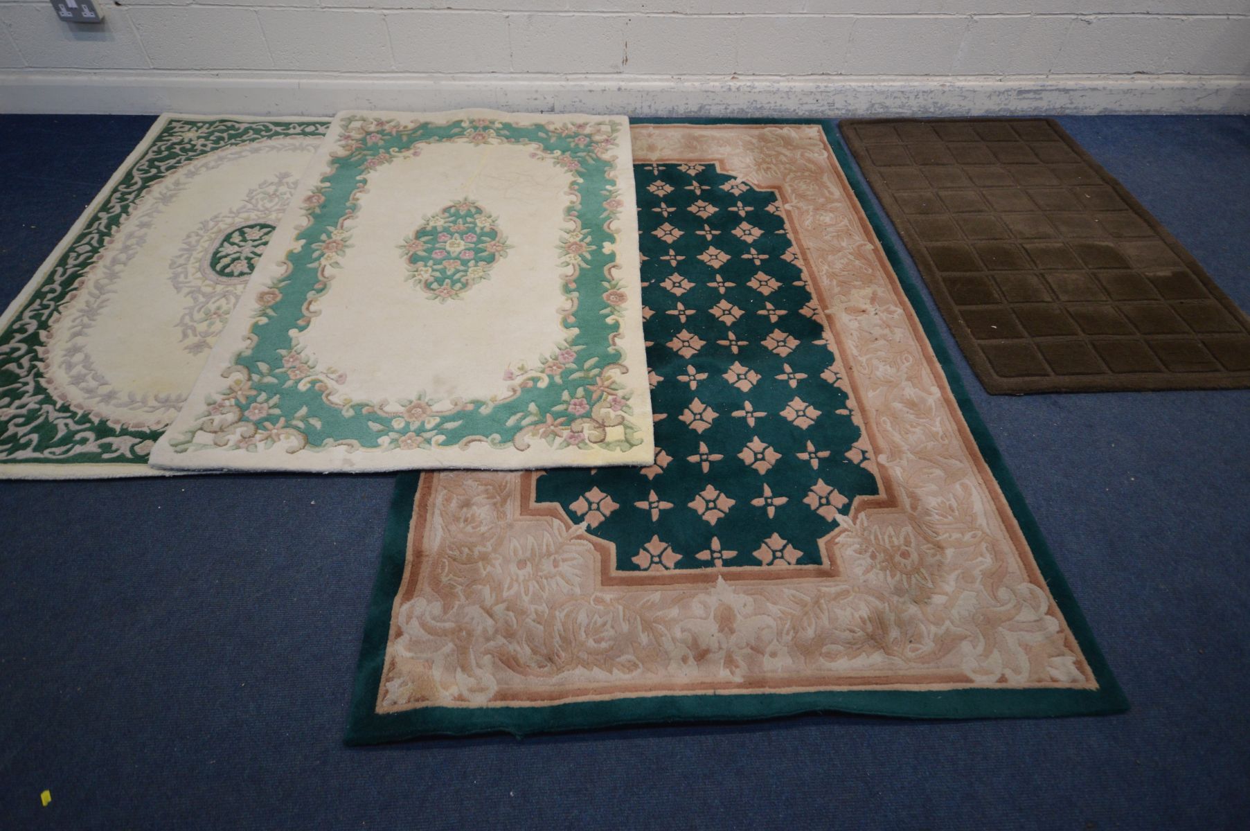 A LARGE GREEN CHINESE WOOLEN RUG, 240cm x 150cm, two similar cream and green ground rugs, both 180cm