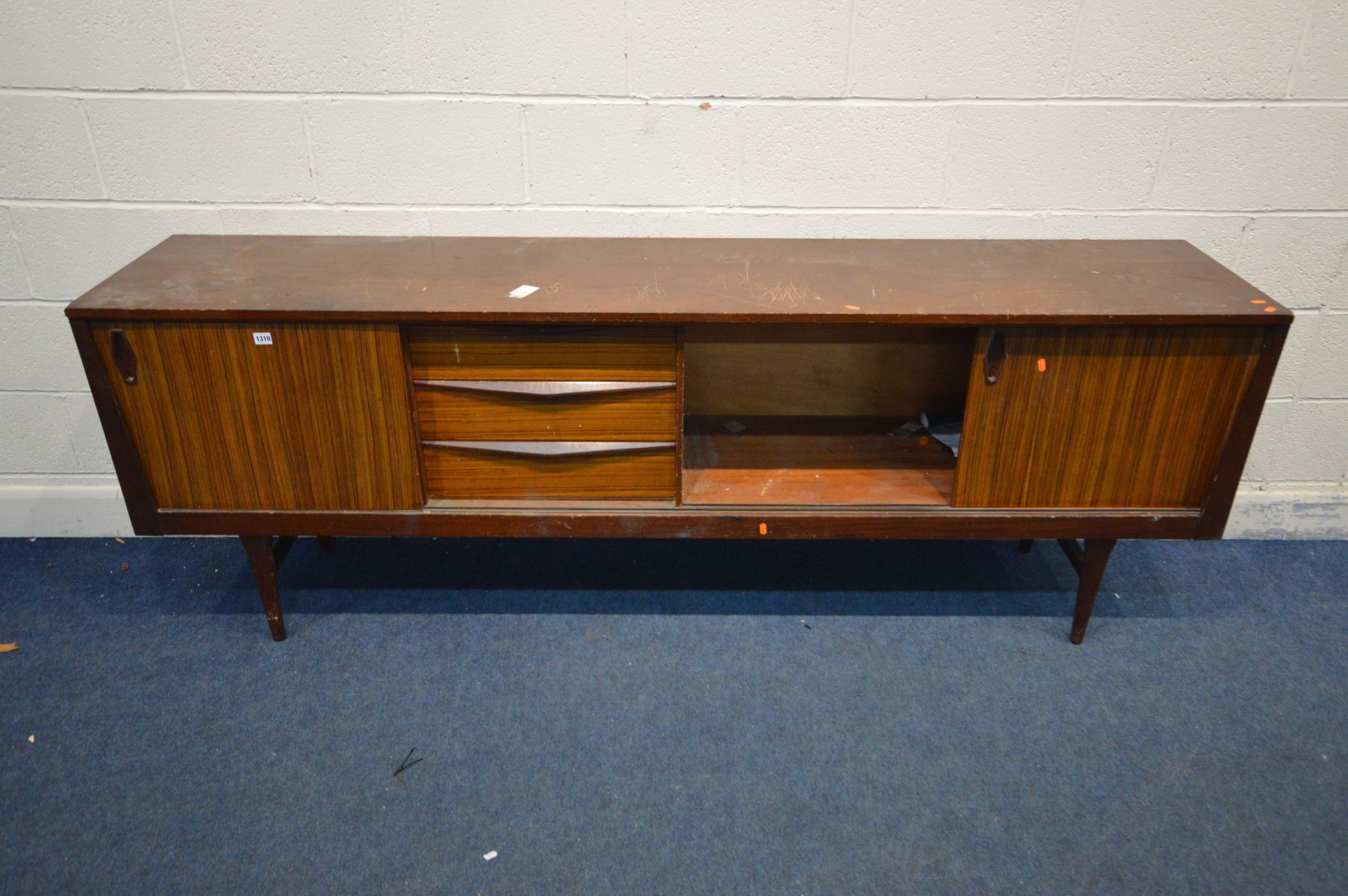 AN AFROMOSIA SIDEBOARD with zebrawood sliding doors and three drawers, on tapering legs, width 221cm