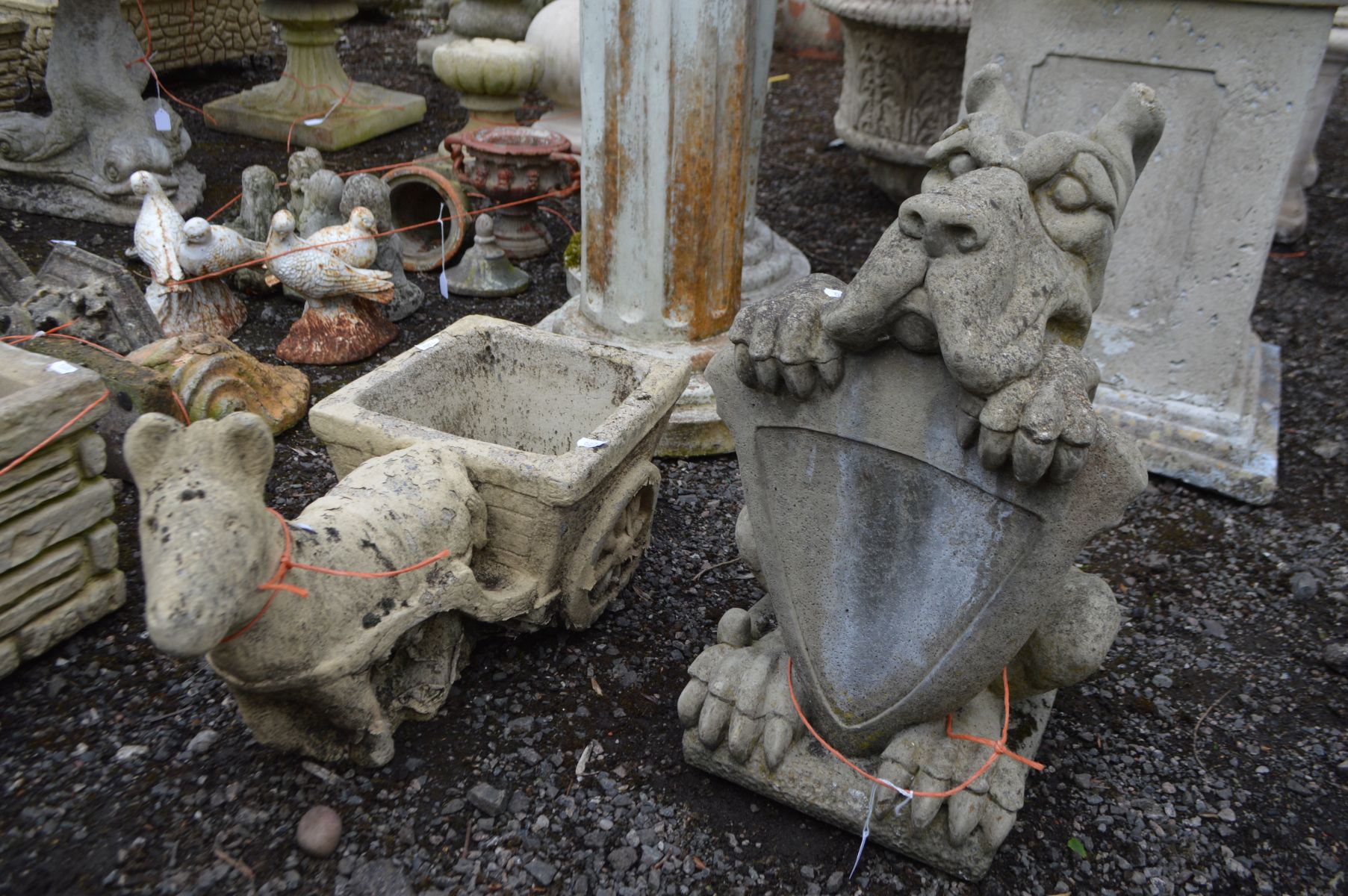 A COMPOSITE GARDEN FIGURE of a hound holding a shield, along with a composite planter of a donkey