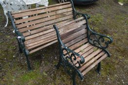 A CAST IRON GREEN PAINTED GARDEN BENCH with teak slats, length 130cm and a matching armchair, length