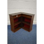 A SMALL EARLY 20TH CENTURY MAHOGANY CORNER OPEN BOOKCASE, with later added red fabric to