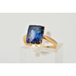 A YELLOW METAL RING, designed with a claw set, rectangular cut synthetic blue sapphire,