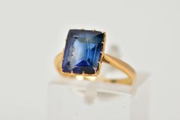 A YELLOW METAL RING, designed with a claw set, rectangular cut synthetic blue sapphire,