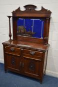 AN EDWARDIAN WALNUT MIRRORBACK SIDEBOARD, raised back on twin pillar supports, on a base with two