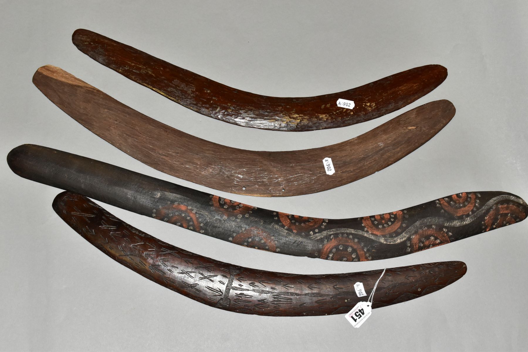 FOUR TRIBAL ART AUSTRALIAN ABORIGINAL BOOMERANGS, to include one carved to the side of arrows,