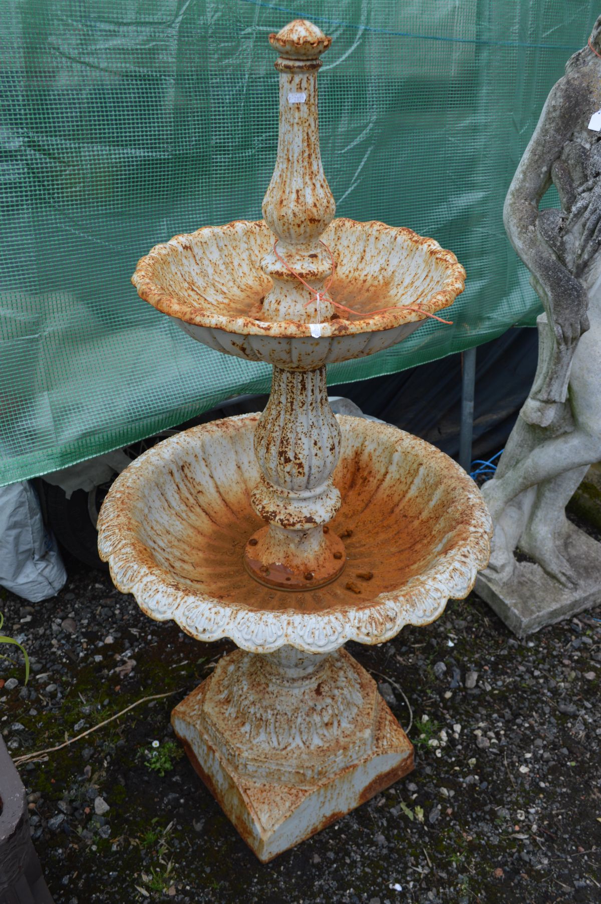 A CAST IRON GRADUATED TWO TIER WATER FEACHURE, later painted white and rusted, on a square base