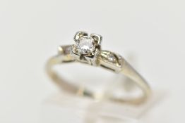 A WHITE METAL DIAMOND RING, centring on a round brilliant cut diamond, total estimated diamond