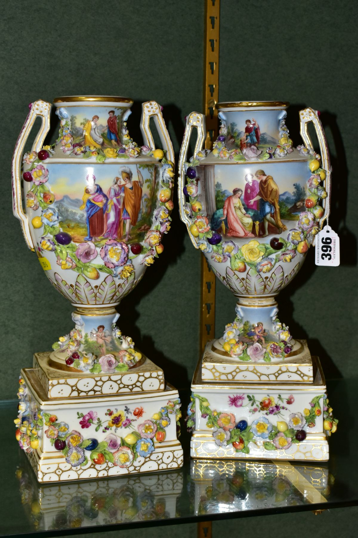 A PAIR OF EARLY 20TH CENTURY POTSCHAPPEL PORCELAIN TWIN HANDLED FLORAL ENCRUSTED VASES ON PLINTHS,