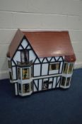 A LARGE WOODEN DOLLS HOUSE in the style of a Tudor house, rear opening to reveal six rooms over