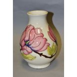 A MOORCROFT POTTERY BALUSTER VASE DECORATED WITH PINK MAGNOLIA ON A CREAM GROUND, painted WM in