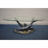 AN OVAL GLASS TOP COFFEE TABLE SUPPORTED ON TWO RESIN DOLPHINS lying on a sea bed, width 120cm x