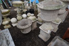 A PAIR OF LARGE COMPOSITE FOLIATE DECORATED URNS with , on separate matched plinths with Art Nouveau