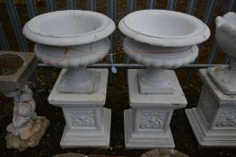 A PAIR OF COMPOSITE CAMPANA GARDEN URNS, later painted white, on a separate plinth, diameter 46cm