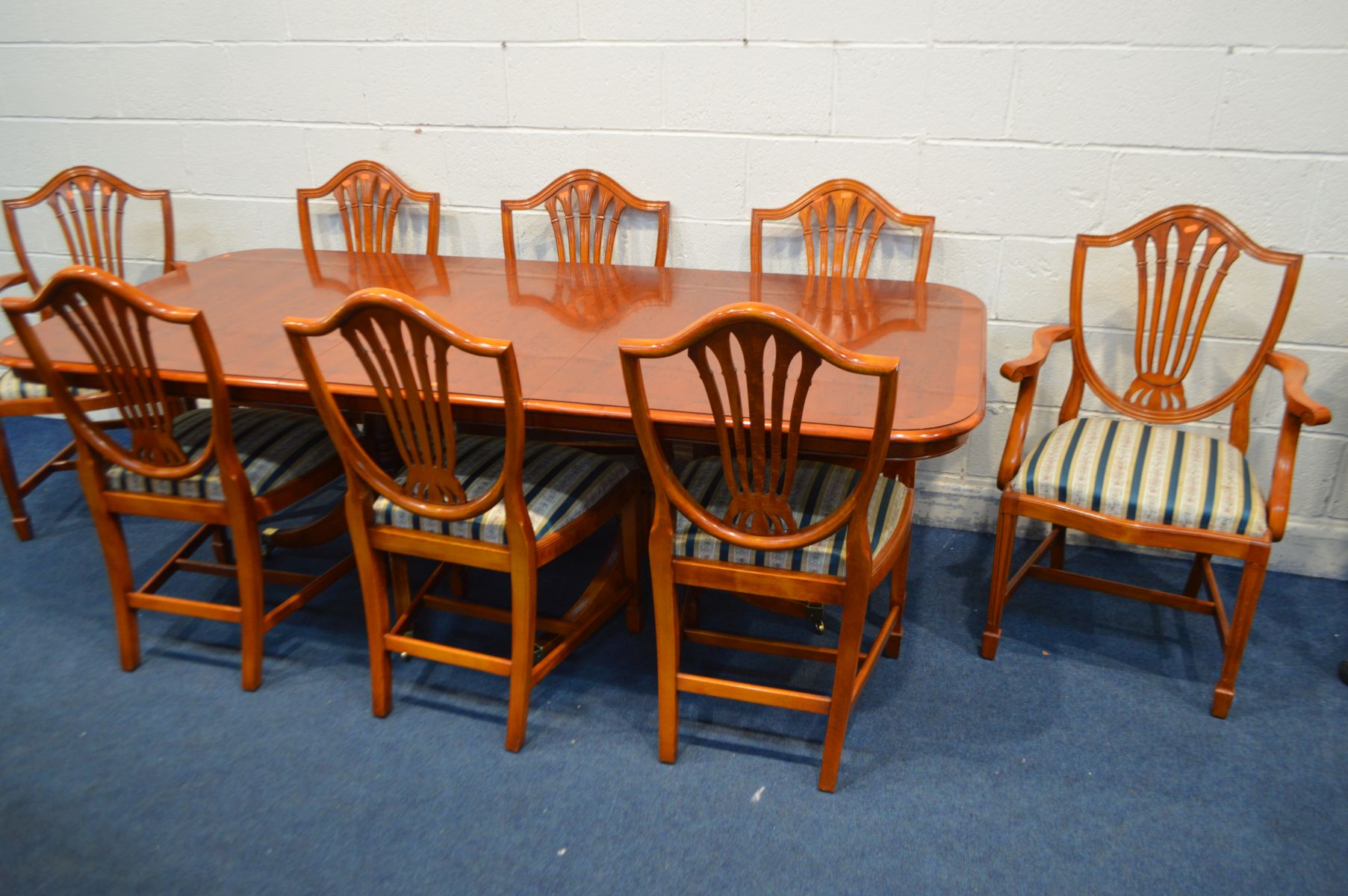 A REPRODUCTION YEWWOOD TWIN PEDESTAL DINING TABLE, with one additional leaf, extended length 217cm x