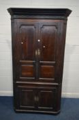 A LARGE OAK GEORGIAN FREESTANDING CORNER CUPBOARD, fixed cornice above double fielded panels doors