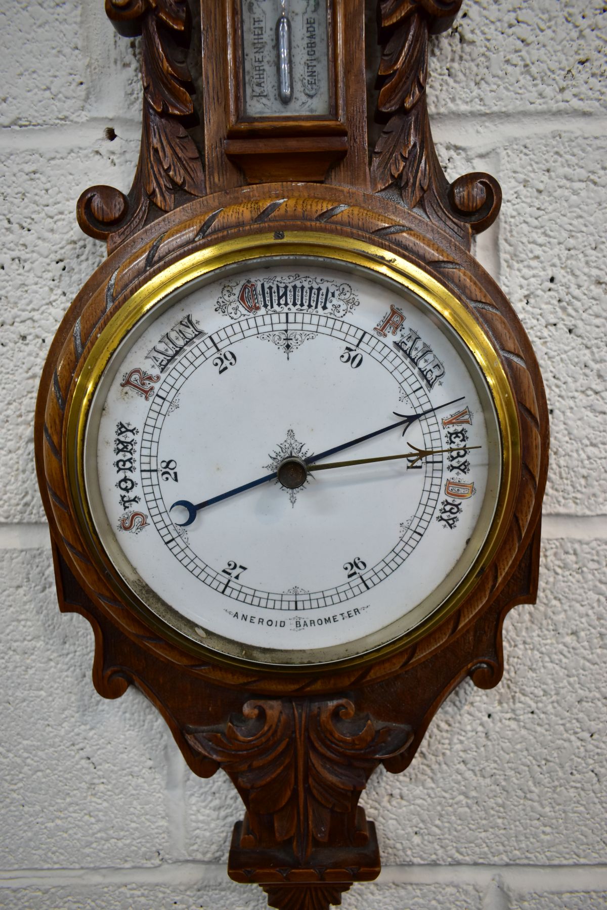 A LATE VICTORIAN CARVED OAK ANEROID BAROMETER, with mercury thermometer and working blued indicator, - Image 2 of 3