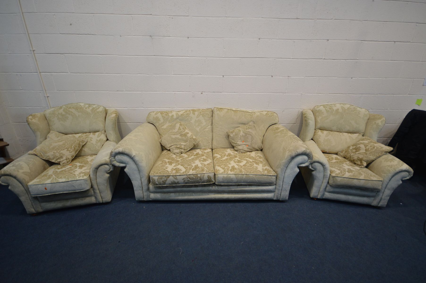 A CREAM UPHOLSTERED THREE PIECE SUITE comprising a settee, width 209cm and a pair of armchairs (3)