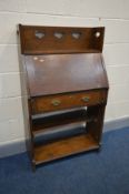 AN ARTS AND CRAFTS OAK SLIM BUREAU, with a raised back with pierced heart decoration, fall front