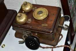 AN EARLY 20TH CENTURY WOODEN WALL PHONE WITH BRASS MOUNTS, ear piece hanging to the left side with