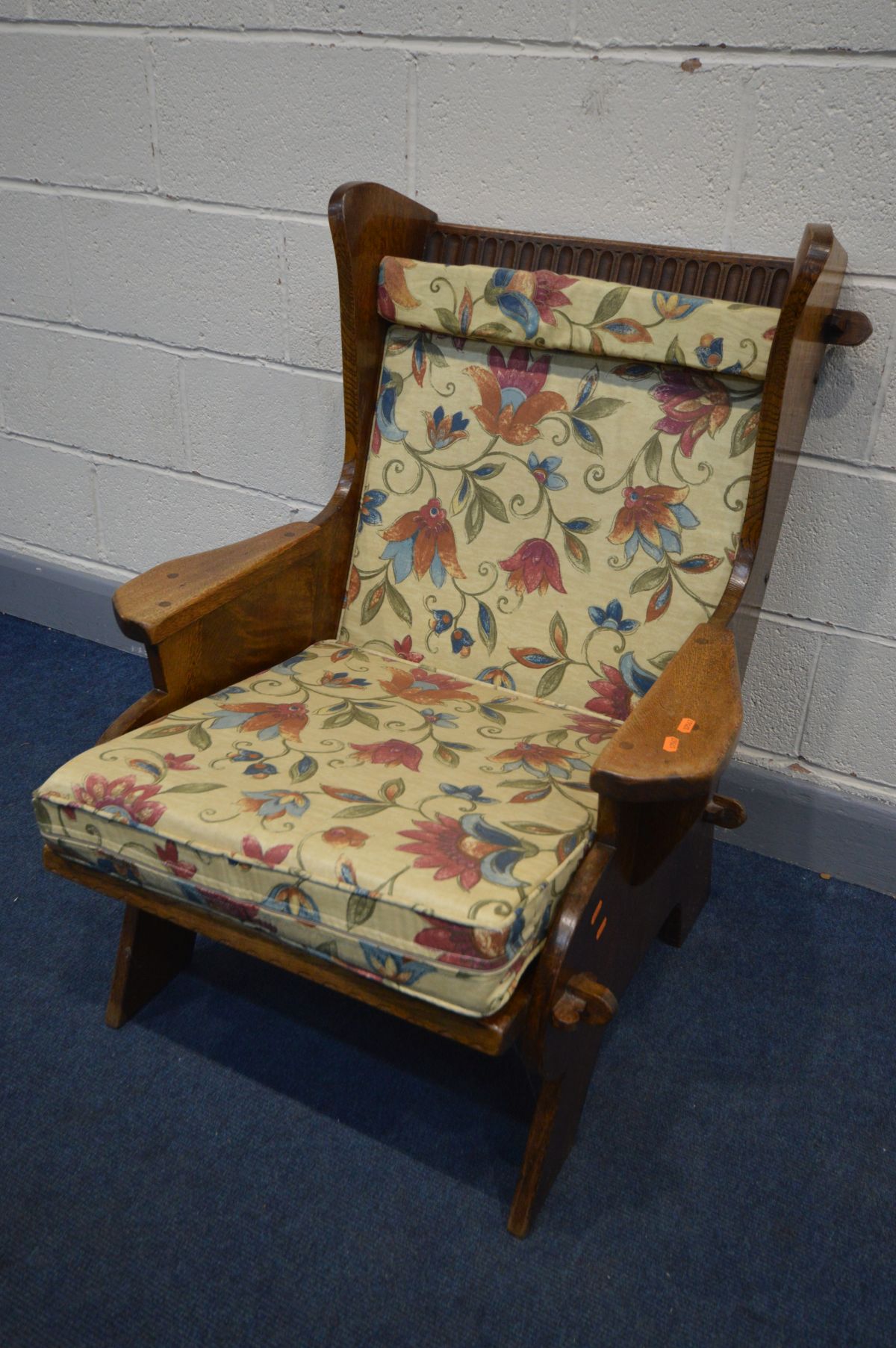 AN ARTS AND CRAFTS OAK ARMCHAIR, with open peg joints, and later cushions, width 73cm x inner seat