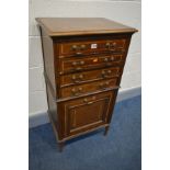 AN EDWARDIAN MAGHOGANY AND INLAID MUSIC CABINET, with four drawers and a fall front compartment on