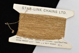 A LENGTH OF 9CT GOLD UNUSED CURB LINK CHAIN, tested as 9ct gold, wrapped around a 'Star-Link