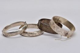 THREE SILVER BANGLES AND ONE OTHER, to include a wide hinged bangle with a decorative floral