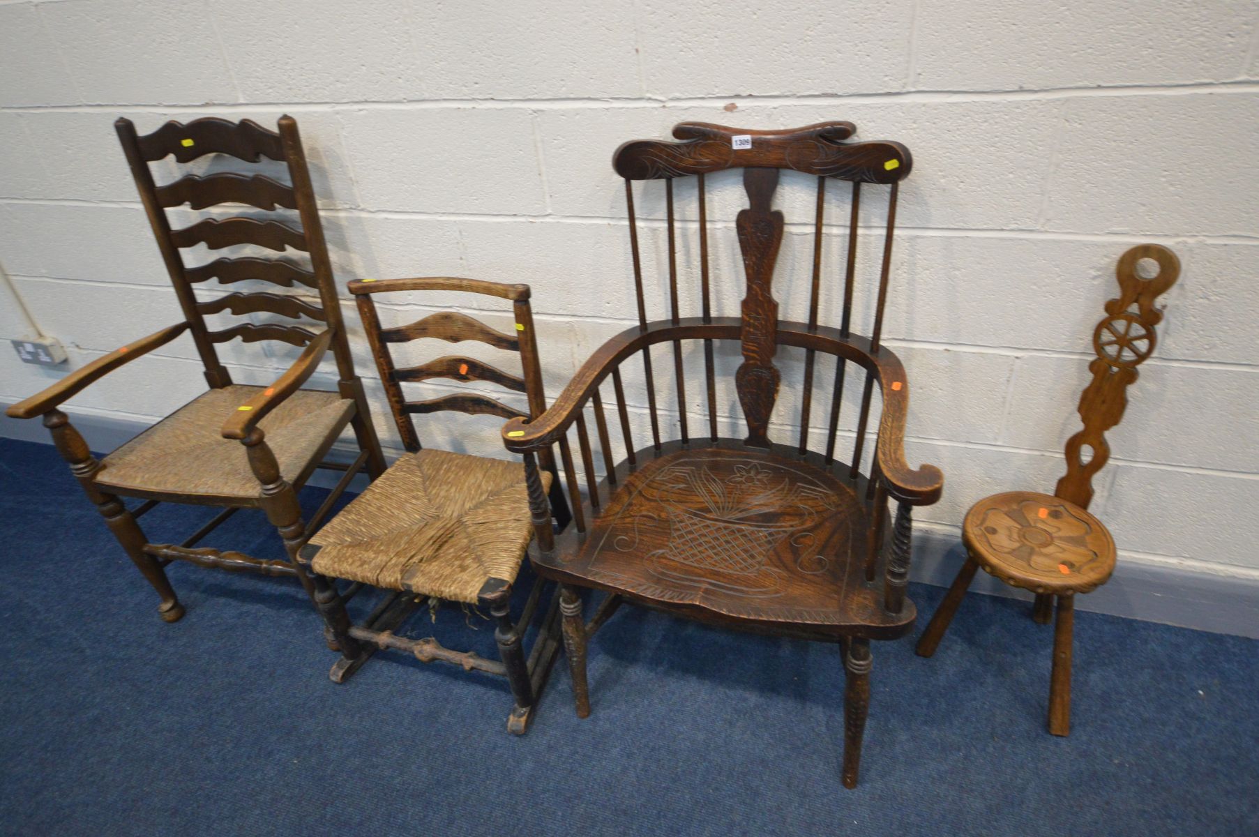 A 20TH CENTURY OAK COMB BACK WINDSOR ARMCHAIR, with carved decoration, along with a spinning