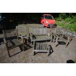 A MATCHED SEVEN PIECE TEAK GARDEN SET, comprising a settee, five armchairs and a pouffe (Sd and