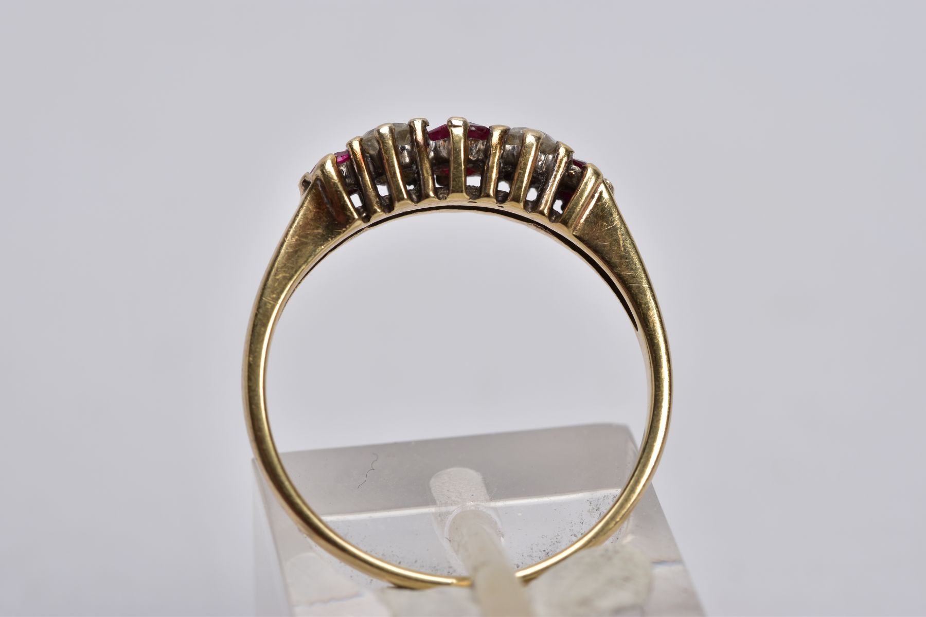 A 9CT GOLD RUBY AND DIAMOND RING, designed with three graduated circular cut rubies, interspaced - Image 4 of 4