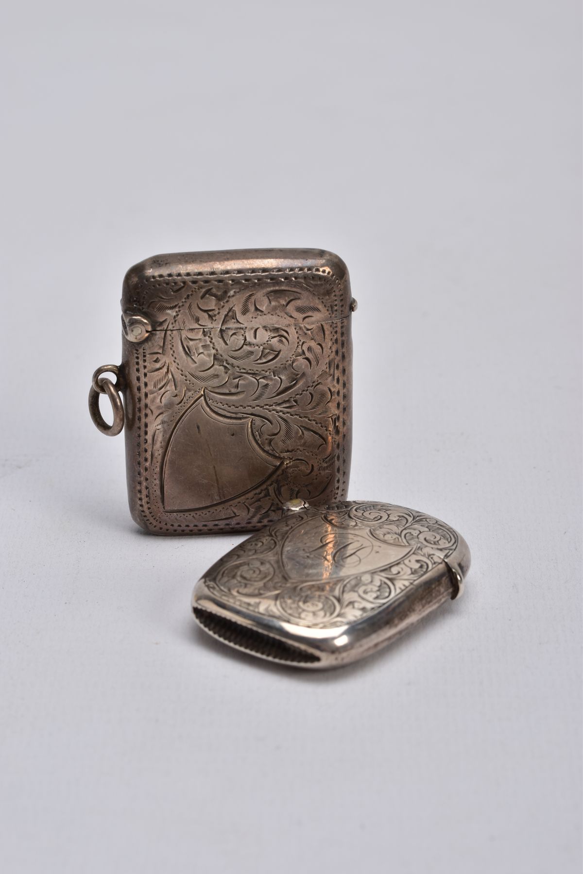 TWO SILVER VESTA CASES, the first of a rectangular form, foliate engraved design, vacant shield