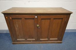 A LATE 19TH/EARLY 20TH CENTURY OAK PANELLED TWO DOOR CABINET, enclosing later fitted shelving, width