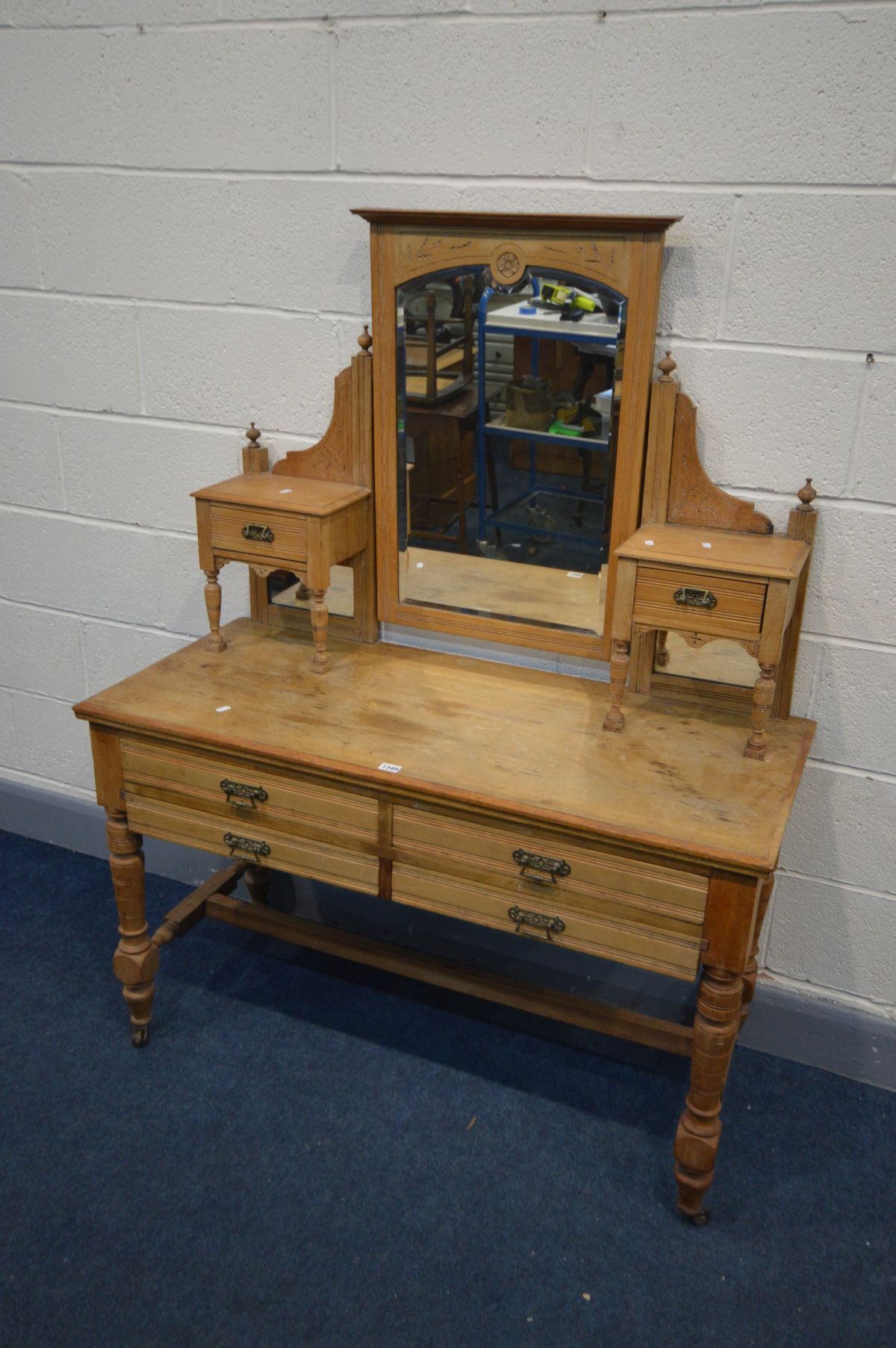 AN EDWARDIAN ASH DRESSING TABLE with a bevelled edge swing mirror flanked by two single drawers,