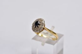 A YELLOW METAL SAPPHIRE AND DIAMOND CLUSTER RING, designed with a central oval cut blue sapphire,