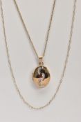 A 9CT GOLD LOCKET PENDANT NECKLACE, the locket of an oval form, engraved with foot prints to the